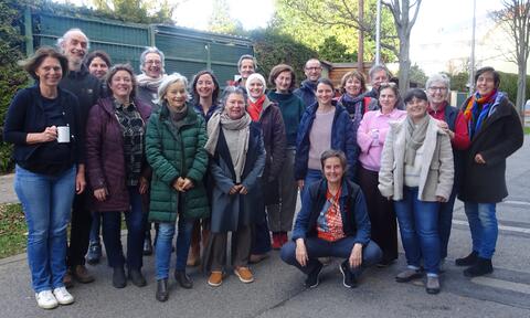 Auf dem Foto stehen die Teilnehmenden mit der Referentin in einem Außenbereich zusammen und lächeln.